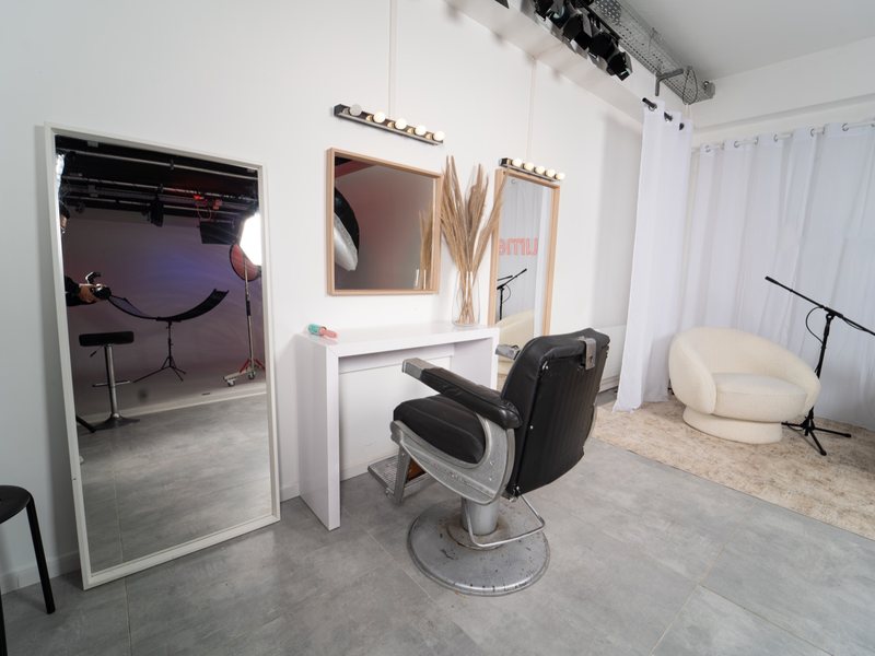 L'espace make-up du Studio Urban : fauteuil de barbier, miroirs à ampoules, cabine d'essayage et coin salon.